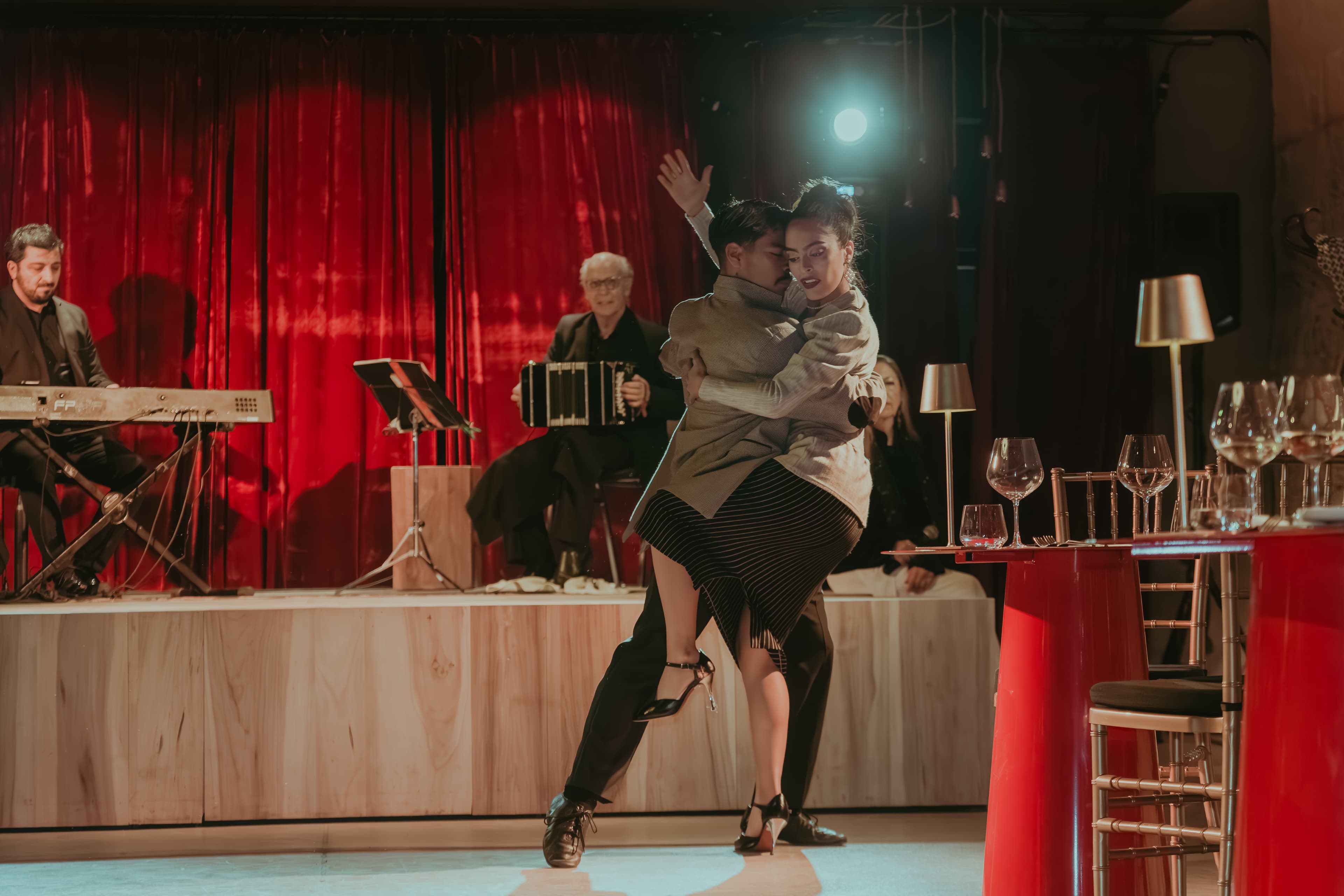 Casal dançando tango em restaurante de Mendoza com luz de velas